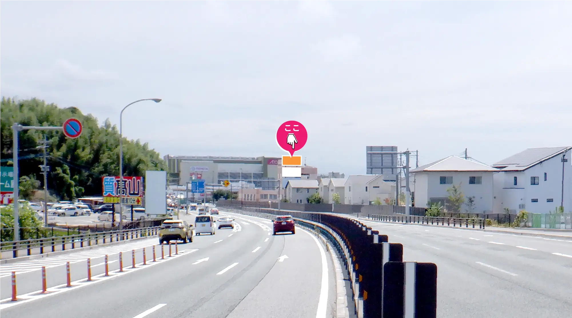 国道3号線の緩やかなカーブ先に見える看板。高い位置に設置され、進行方向の正面に大きく見える長い視認距離を証明する写真